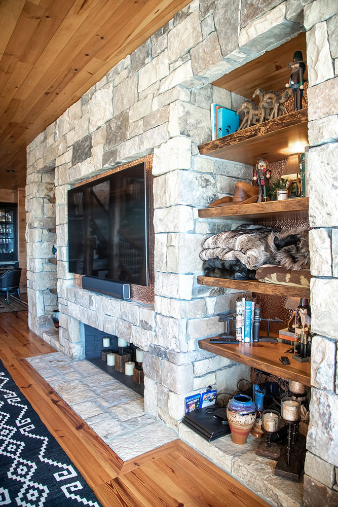 Custom wood shelves next to a stone fireplace